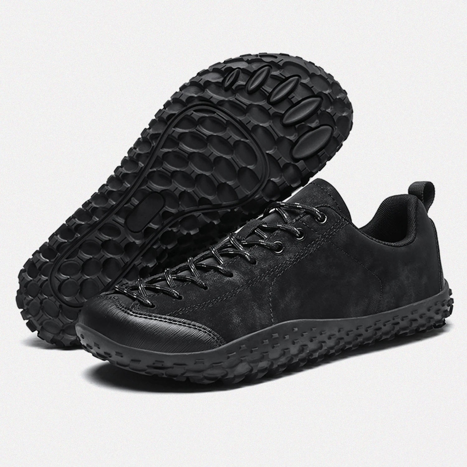 Dannto black barefoot trail shoes shown from a three quarter view and the bottom